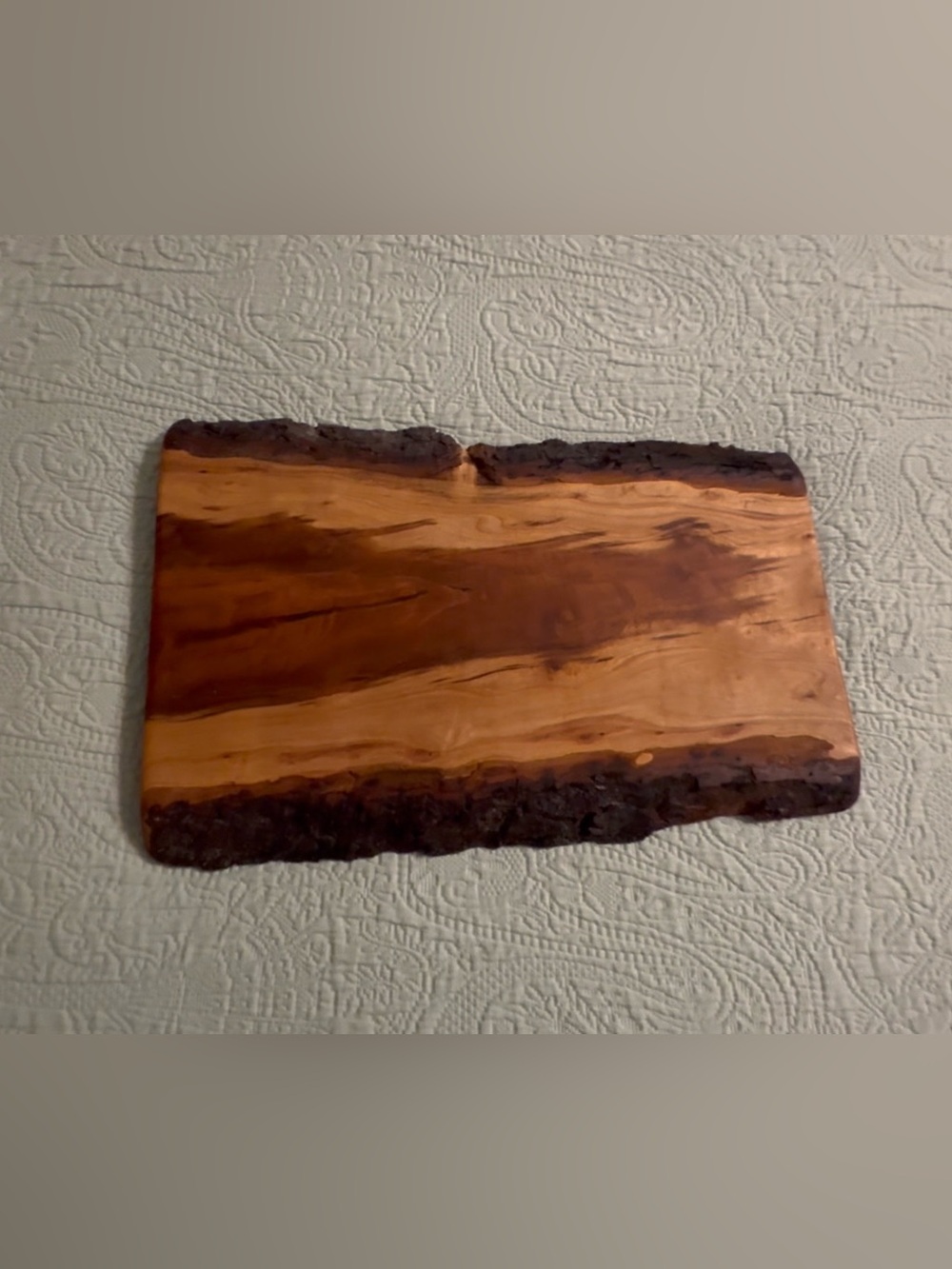 Live edge solid wood cutting board, bark intact, used/good.